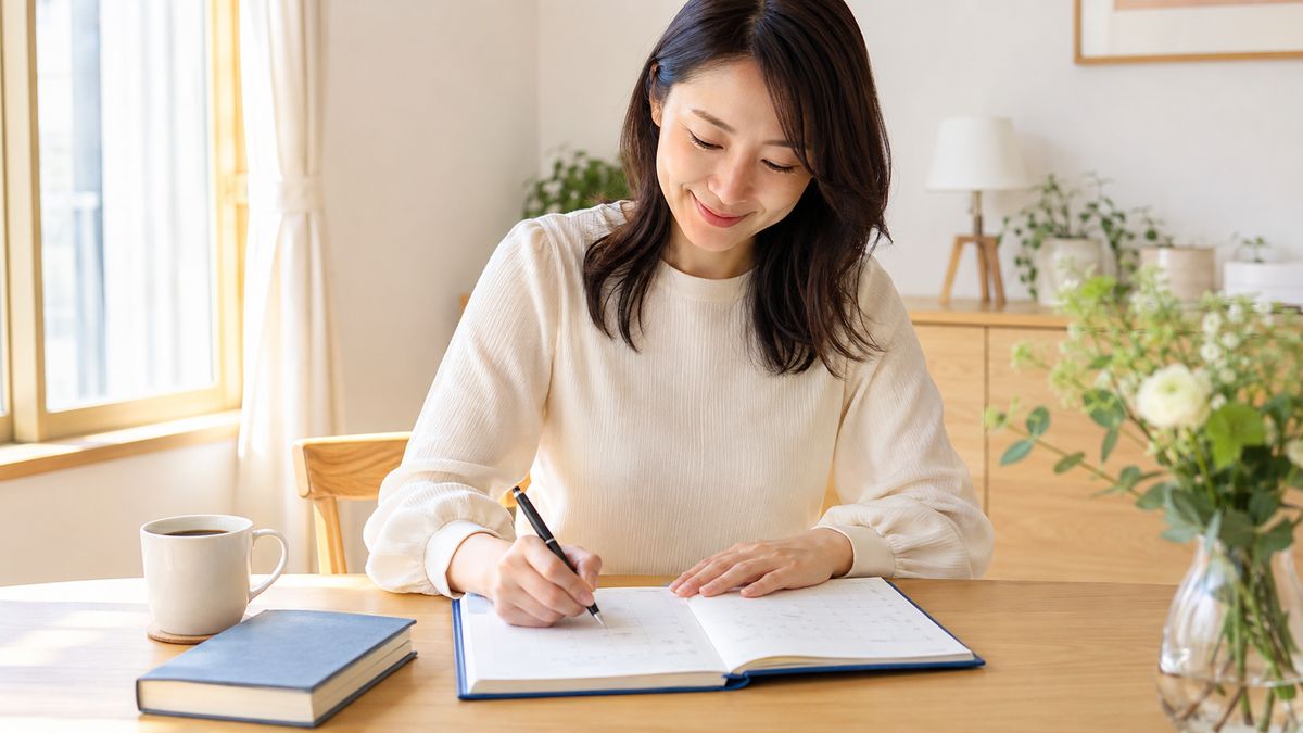 英検1級合格に向けた6ヶ月学習プランを手帳に書き込む日本人社会人女性