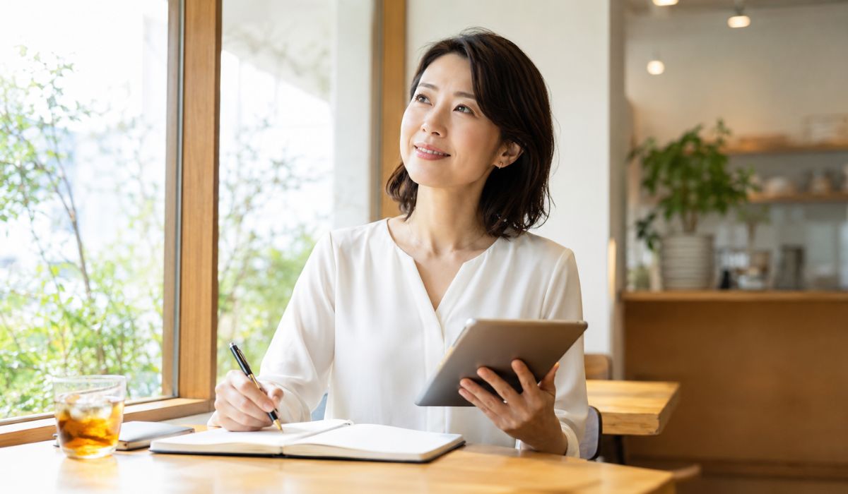 AI時代に英語コーチが必要かどうかをタブレットとノートで整理しながら考える日本人女性