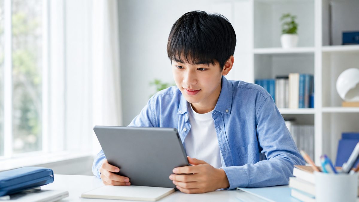 中学生が英検2級を取るメリットの全体像をタブレットで確認する日本人の中学生