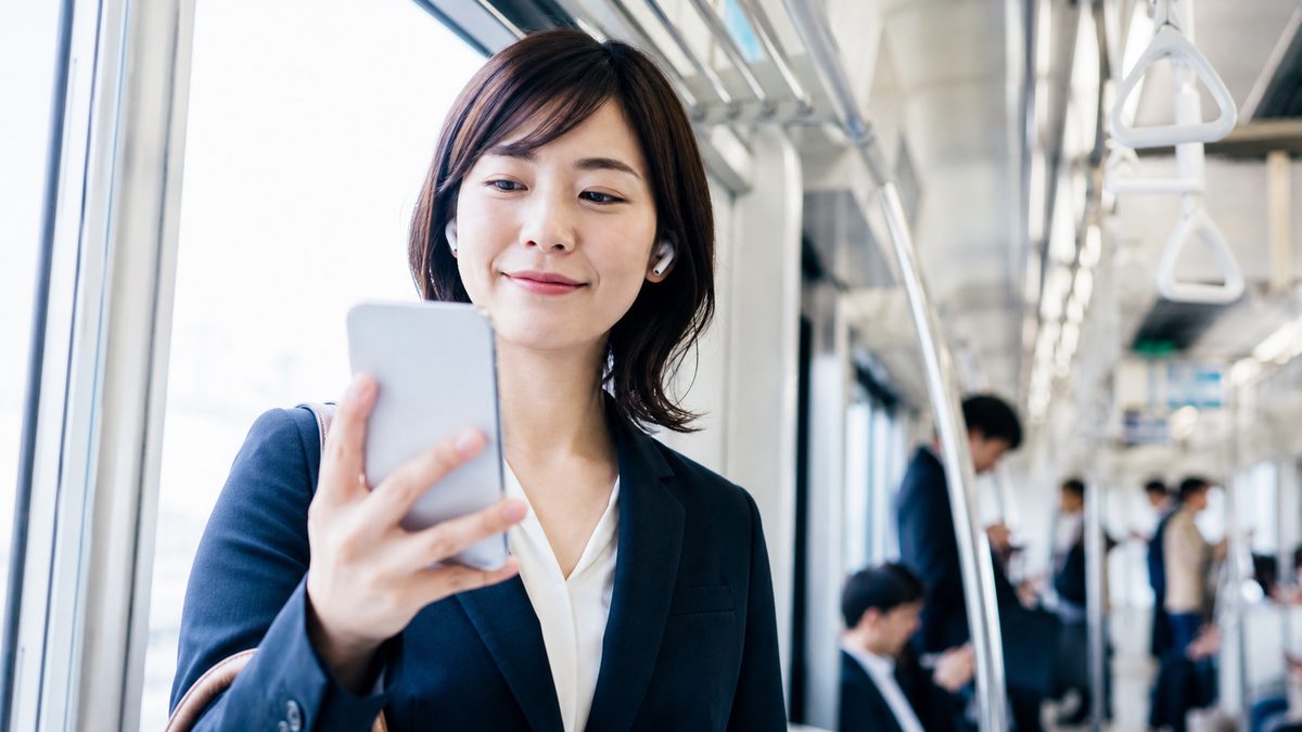 通勤中のスキマ時間にスマートフォンで英検準1級の単語を覚える会社員