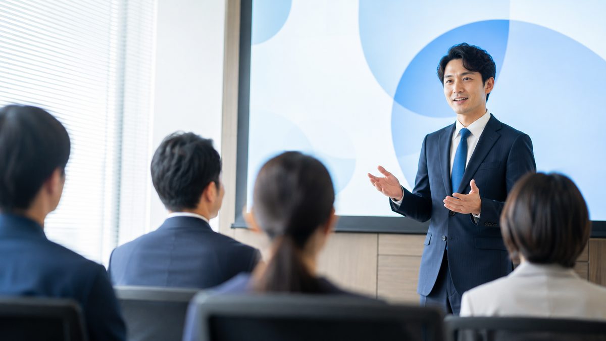 英語プレゼンを聞き手の側から見た会議室の風景と、結論ファーストが伝わっているかを確認する場面