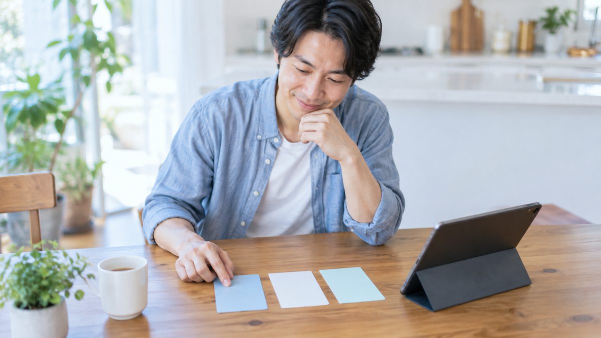 英語コーチングは意味ないのかを考える前に、ダイニングテーブルでタブレットと3枚のカードを並べて受けられる支援を整理する社会人男性