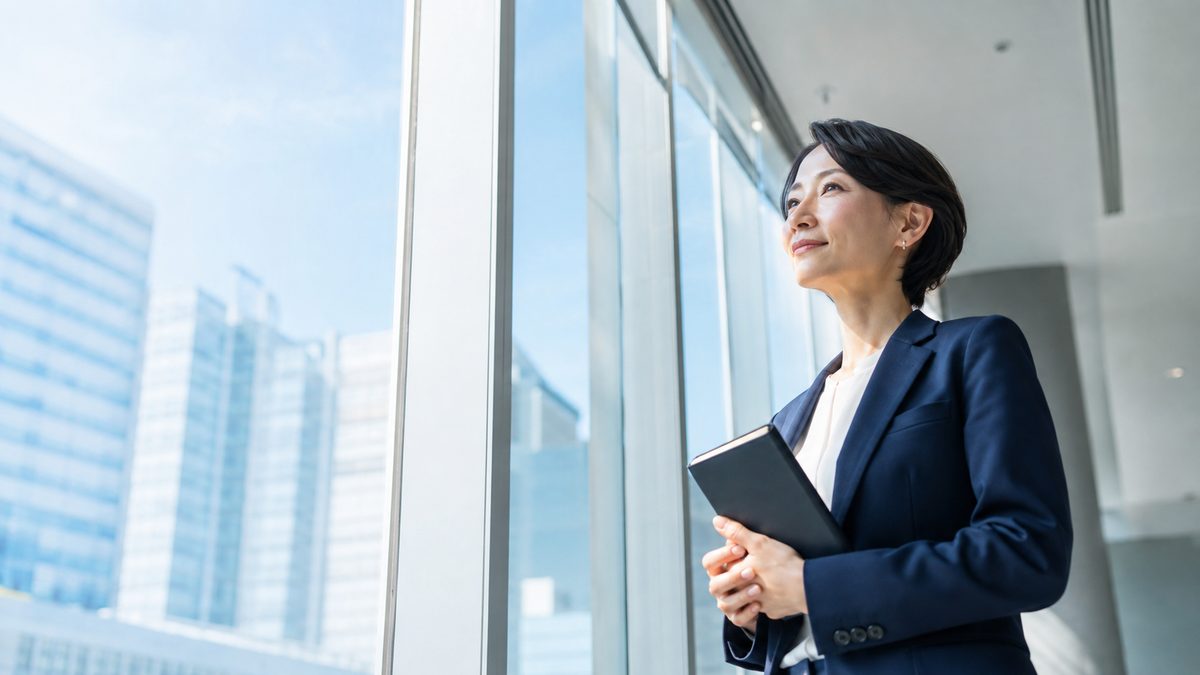 英語が話せない社会人が、これまでの学習の前提を見直すためオフィスの窓辺で考えを整理している場面