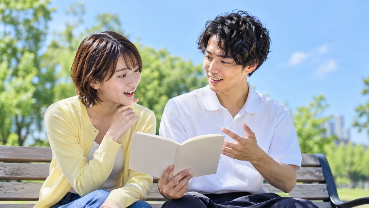 ワーホリの英語力についての疑問を、公園のベンチでノートを見ながら話し合う日本人の若い男女