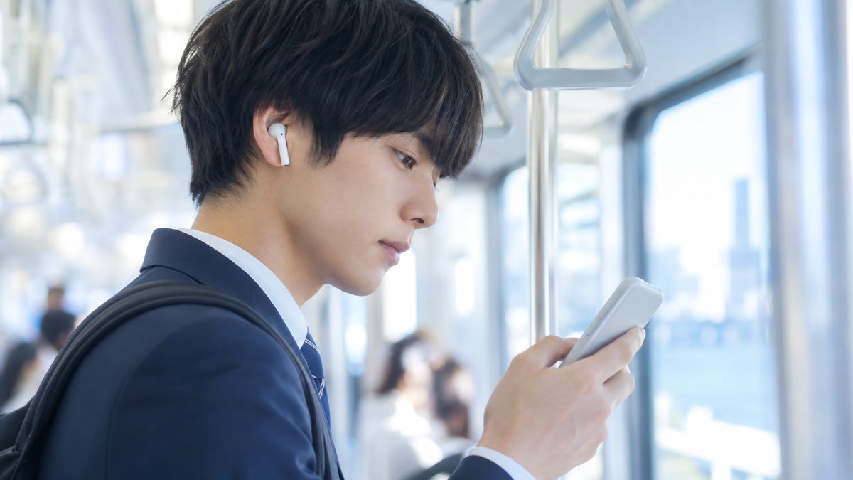ワーホリ前の英語勉強法として、通勤電車でイヤホンをつけて英語のリスニングに集中する日本人男性